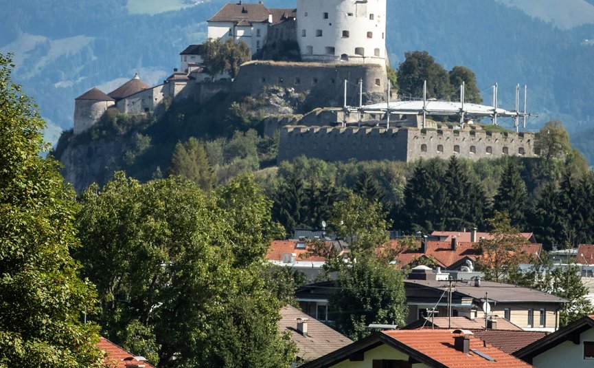 Fietsers rijden voor kasteel Hohenwerfen in de Alpen bij helder weer