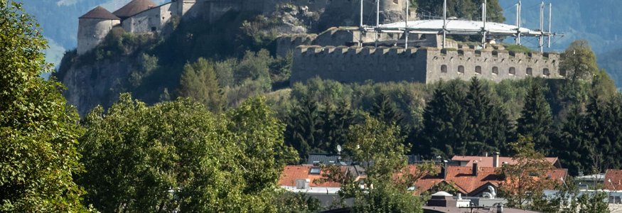 Fahrradfahrer vor Schloss Hohenwerfen in den Alpen bei klarem Wetter