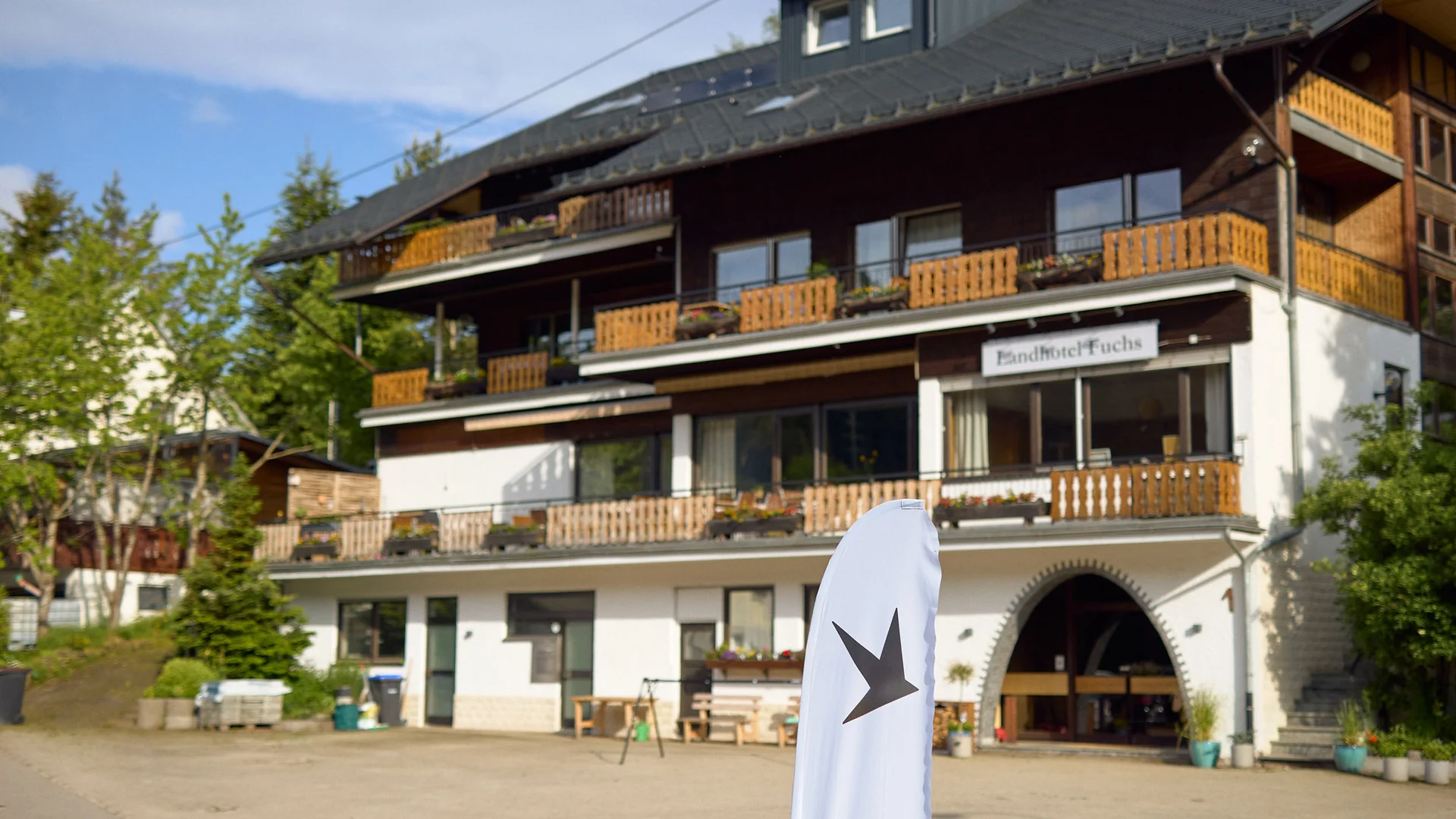 Außenansicht Landhotel Fuchs mit Balkonen und Fahne im Vordergrund