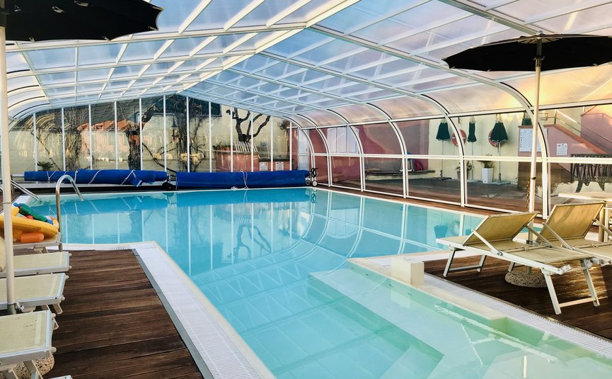 Piscina coperta con lettini e ombrelloni