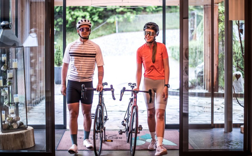 Twee fietsers met helmen en fietsen binnen in een modern gebouw