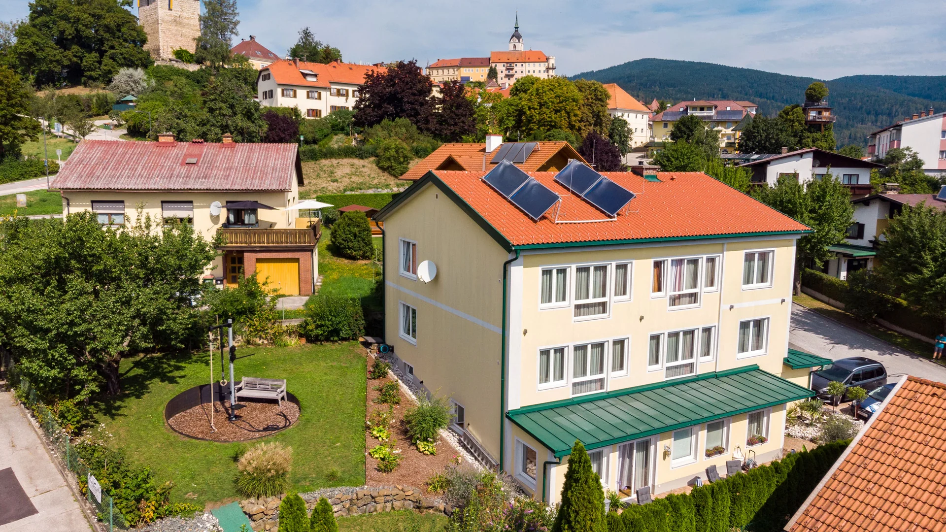 Haus mit Solarpaneelen in einem Dorf mit Schloss im Hintergrund
