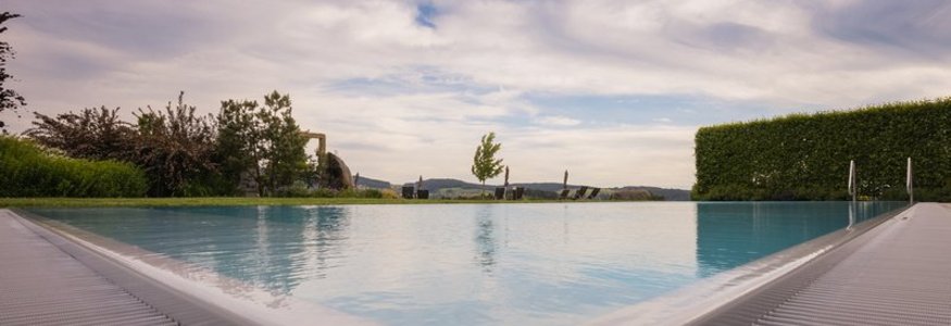 Landrefugium Obermüller ****S © Detail Nicole Schaller Blick auf einen ruhigen Pool mit Landschaft und bewölktem Himmel im Hintergrund