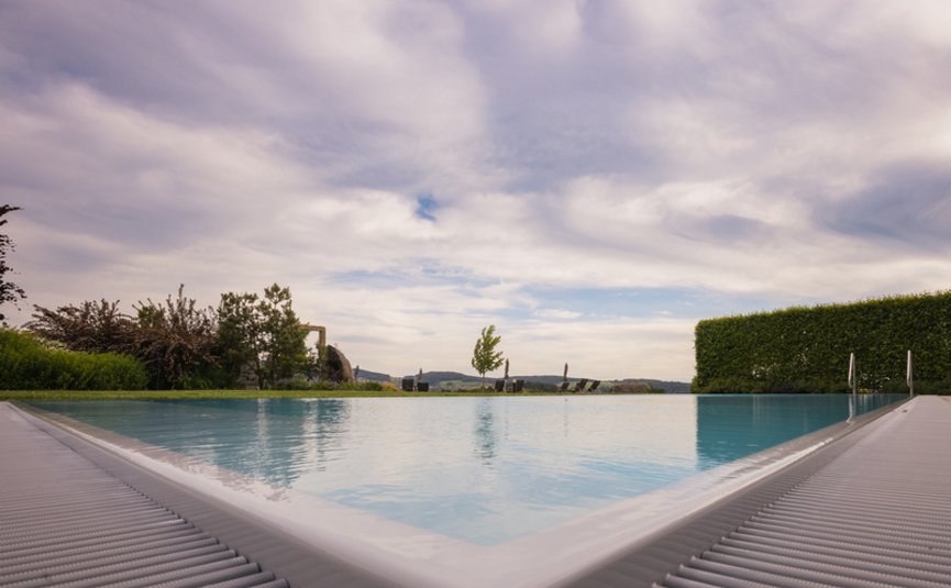 Landrefugium Obermüller ****S © Detail Nicole Schaller Blick auf einen ruhigen Pool mit Landschaft und bewölktem Himmel im Hintergrund
