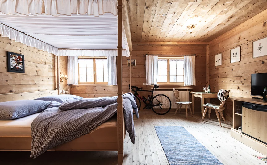 Gämsle Hotel, Wirtshaus & mehr .. © Raffael F. Lehner Cozy wooden bedroom with bike, table, and beds with blue bedding