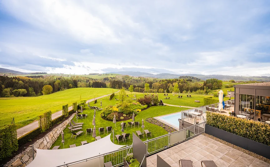 Panorama eines Gartens mit Liegestühlen und Pool auf dem Land