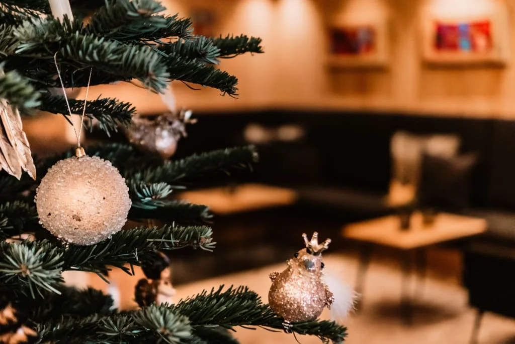 Nahaufnahme eines mit Kugeln und Vogelornament geschmückten Weihnachtsbaums
