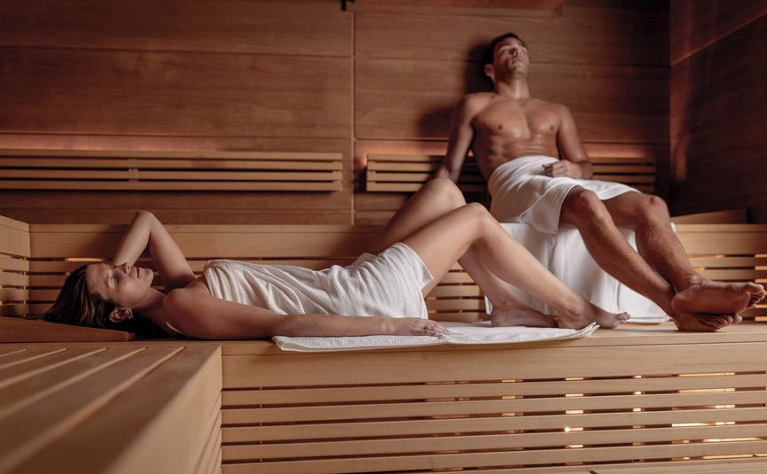 Man and woman relaxing in a wooden sauna