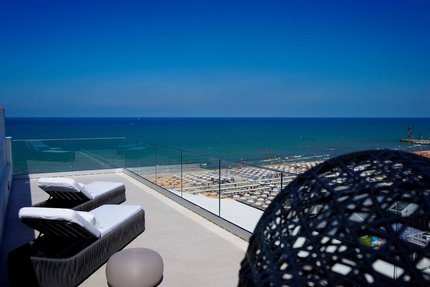 Two loungers overlooking the sea and crowded beach on a sunny day