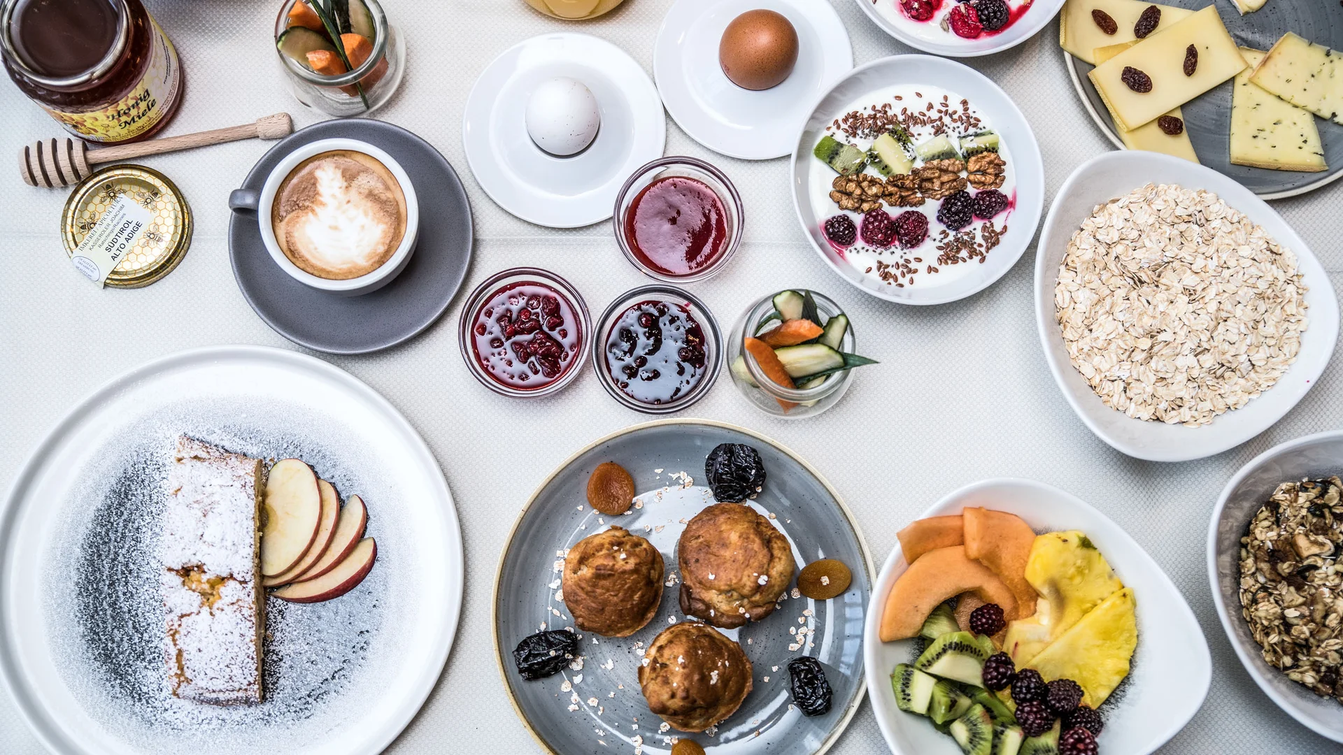 Frühstück mit Kaffee, Eiern, Obst, Joghurt, Käse, Muffins und Marmelade