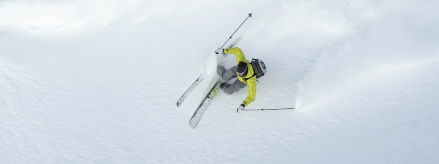 Dolomiti Super Première Sciatore con giacca gialla su neve fresca polverosa