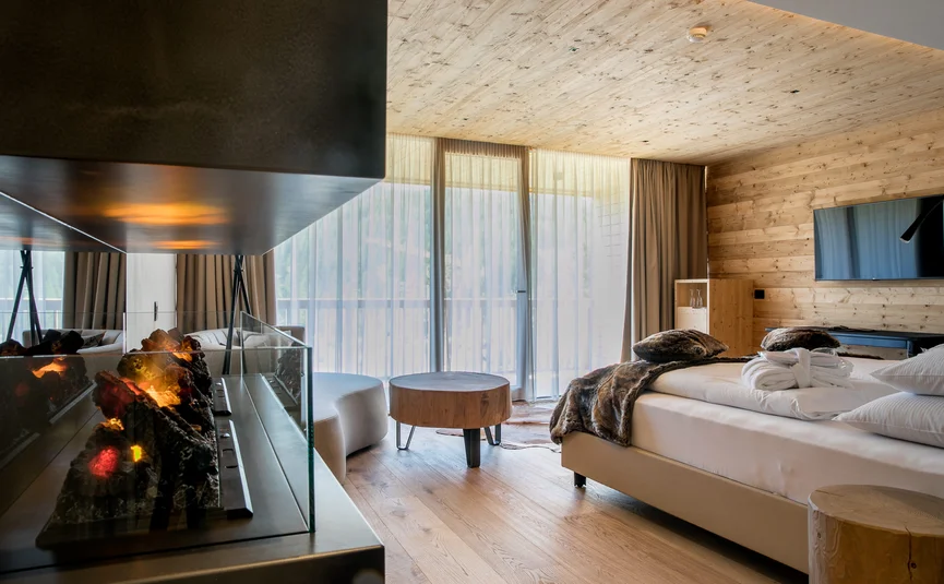 Hotel Gran Paradiso **** © Davide dal Mas Modernes Schlafzimmer mit Kamin, großen Fenstern und Holzwänden