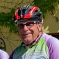 Uomo anziano sorridente con casco da bici e maglia da ciclismo