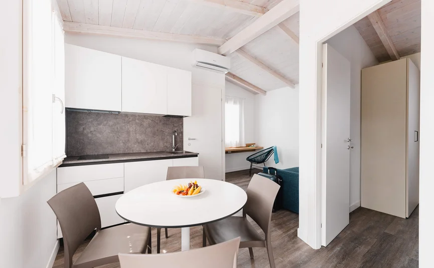 Moderne Küche mit Esstisch und vier Stühlen in einem Appartment