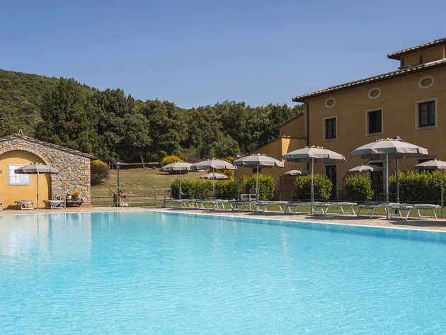 Rennradfahren in der Toskana © Hotel Casolare Le Terre Rosse Pool mit Sonnenschirmen und Liegestühlen vor einem Haus in ländlicher Umgebung