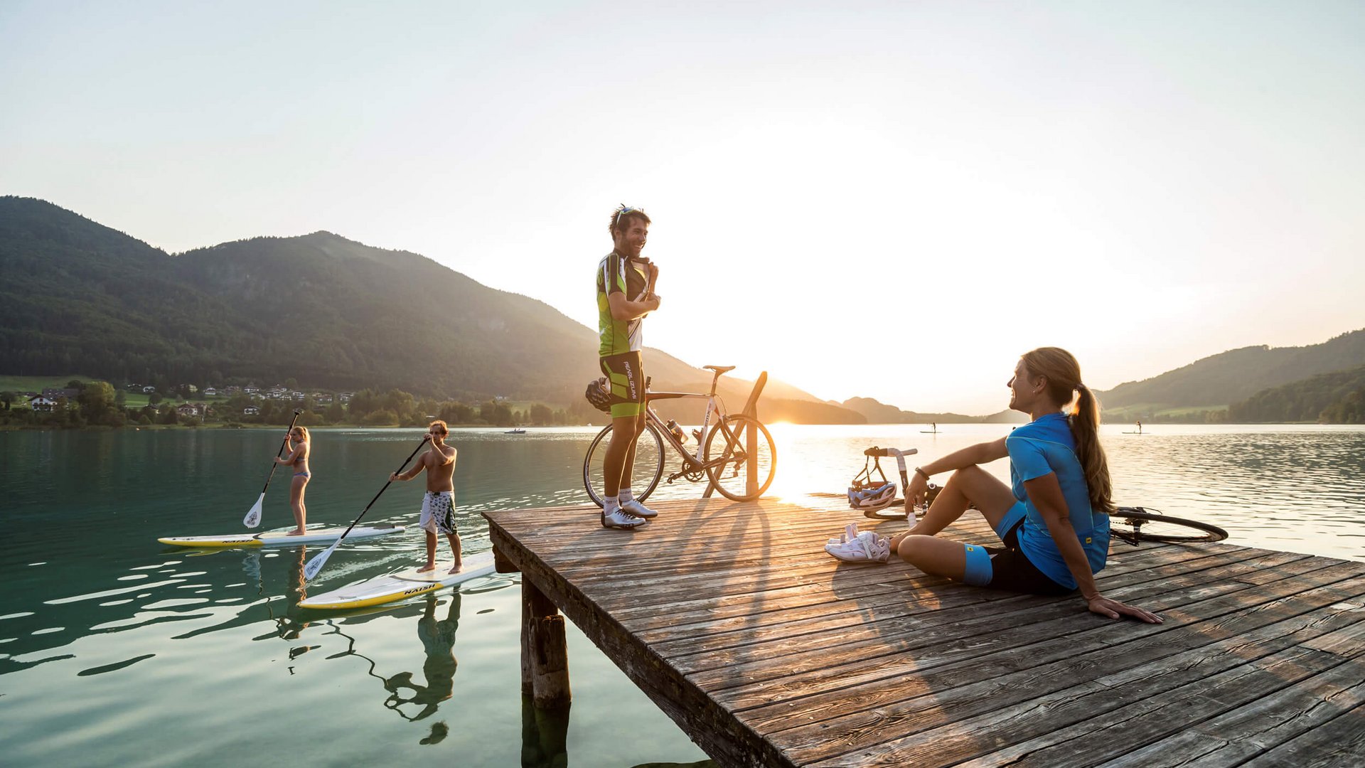 Welcher Rennrad-Typ bist du? © Markus Greber Personen auf Steg und Stand-up-Paddle-Boards bei Sonnenuntergang am See