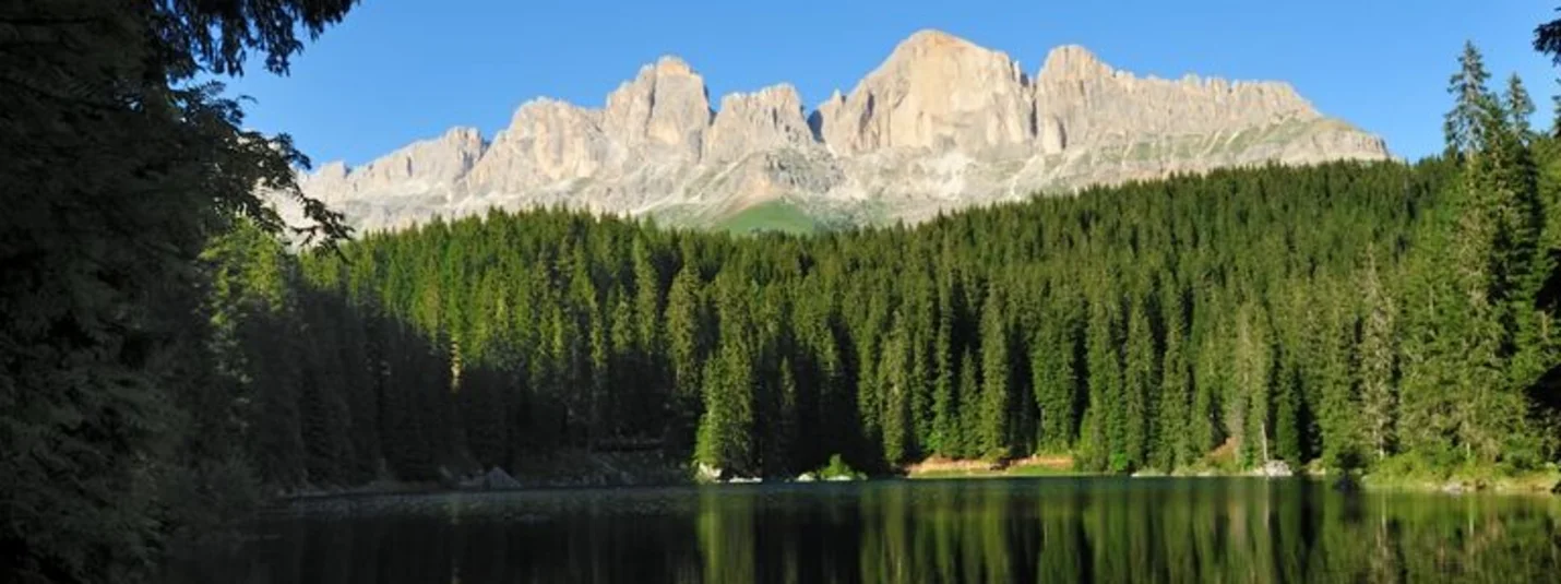 Carezza Passo Latemar Catinaccio © Hotel Teutschhaus Kurtinig Cime montuose e foresta riflesse in un lago calmo