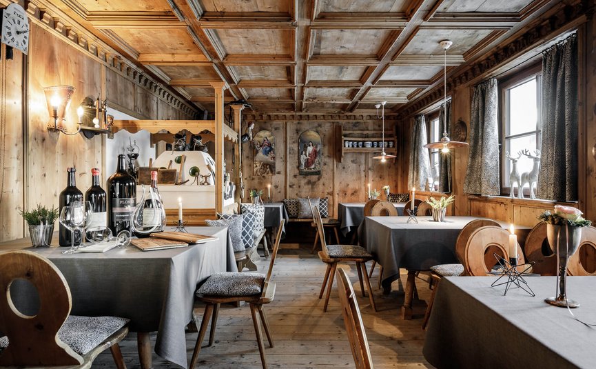 Cozy dining room with wood paneling, set tables and candlelight