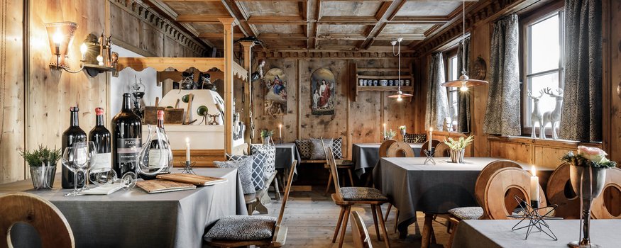 Bike & Kulinarik: Vom Gipfel in den Gourmethimmel © Rudi Wyhlidal Gemütlicher Gastraum mit Holzwänden, gedeckten Tischen und Kerzenlicht