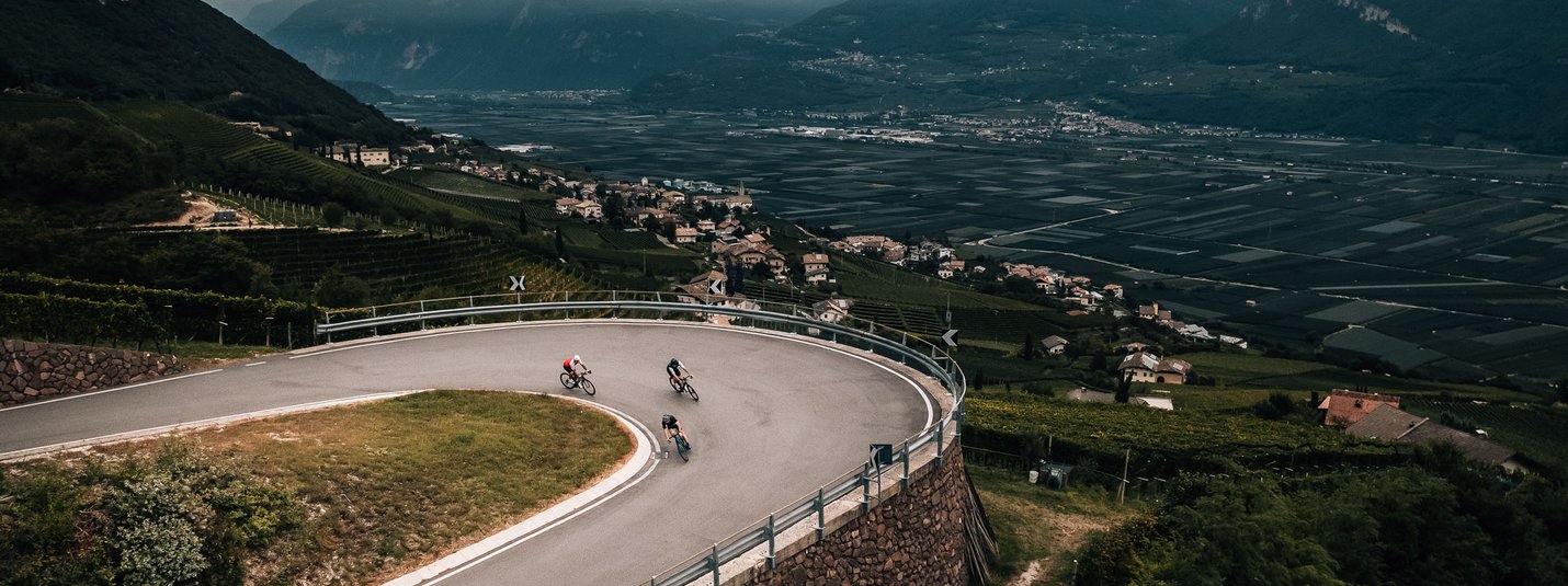 Fennbergersee © Jens Scheibe Drei Radfahrer auf einer Serpentinenstraße in bergiger Landschaft