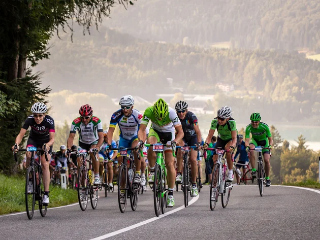 Ein Rennrad-Wochenende im SalzburgerLand – Salzkammergut © Erwin Haiden Radfahrer in einem Straßenrennen auf bergiger Strecke mit Wald und See im Hintergrund
