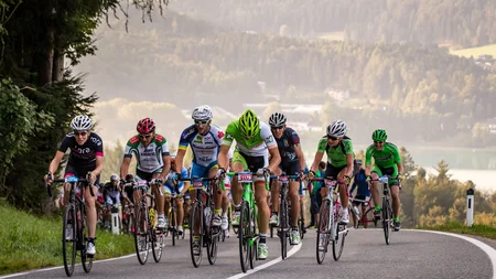 Ein Rennrad-Wochenende im SalzburgerLand – Salzkammergut © Erwin Haiden Radfahrer in einem Straßenrennen auf bergiger Strecke mit Wald und See im Hintergrund