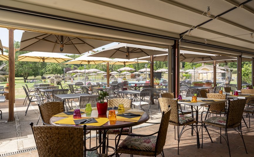 Hotel & Restaurant Casolare Le Terre Rosse ***S © Hotel Casolare Le Terre Rosse Außenrestaurant mit Tischen, Stühlen und Sonnenschirmen im Garten