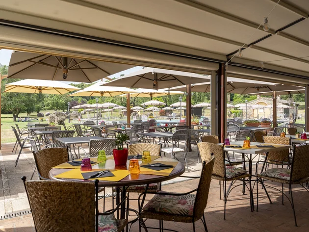 Rennradfahren in der Toskana © Hotel Casolare Le Terre Rosse Außenrestaurant mit Tischen, Stühlen und Sonnenschirmen im Garten