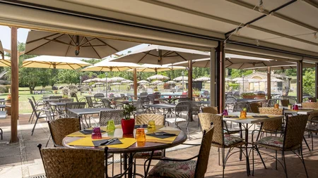 Rennradfahren in der Toskana © Hotel Casolare Le Terre Rosse Außenrestaurant mit Tischen, Stühlen und Sonnenschirmen im Garten
