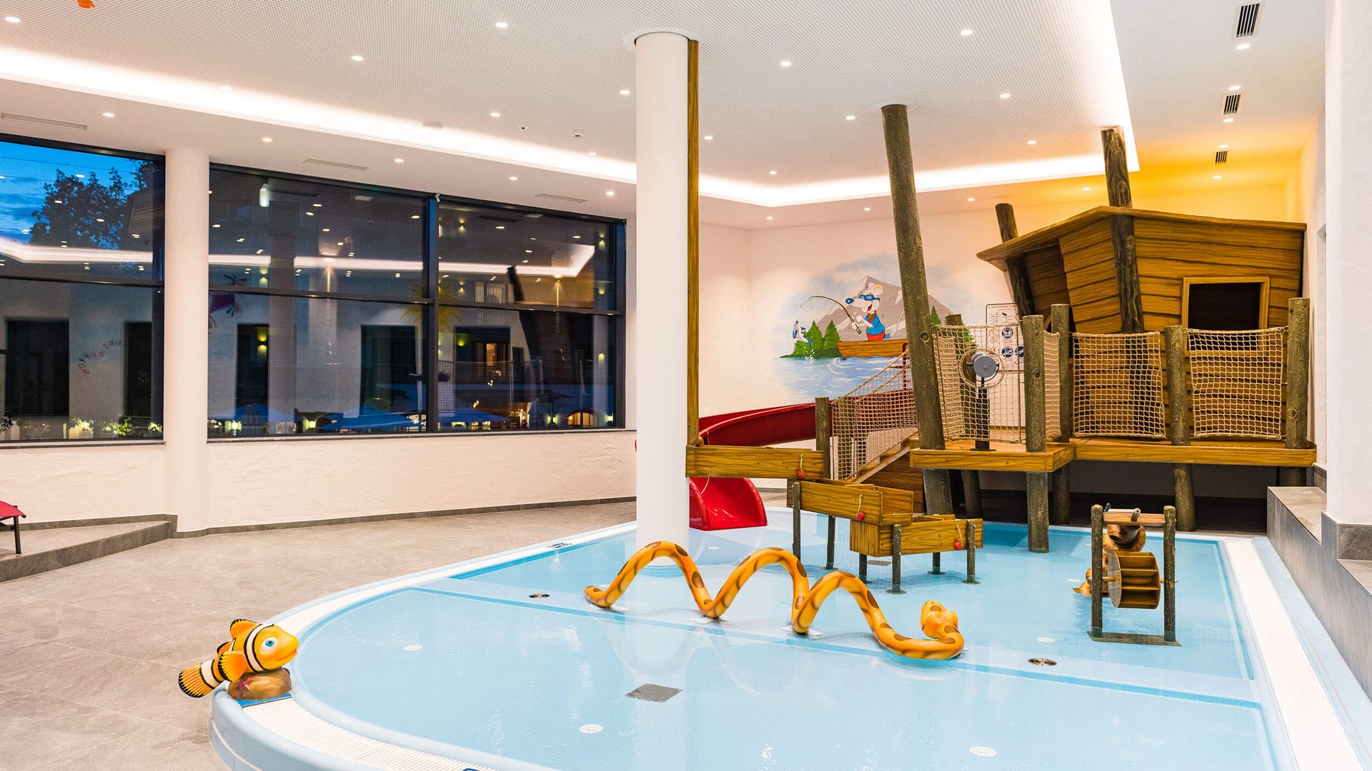 Kinderspielbereich mit kleinem flachem Pool und Holzkonstruktion mit Rutsche