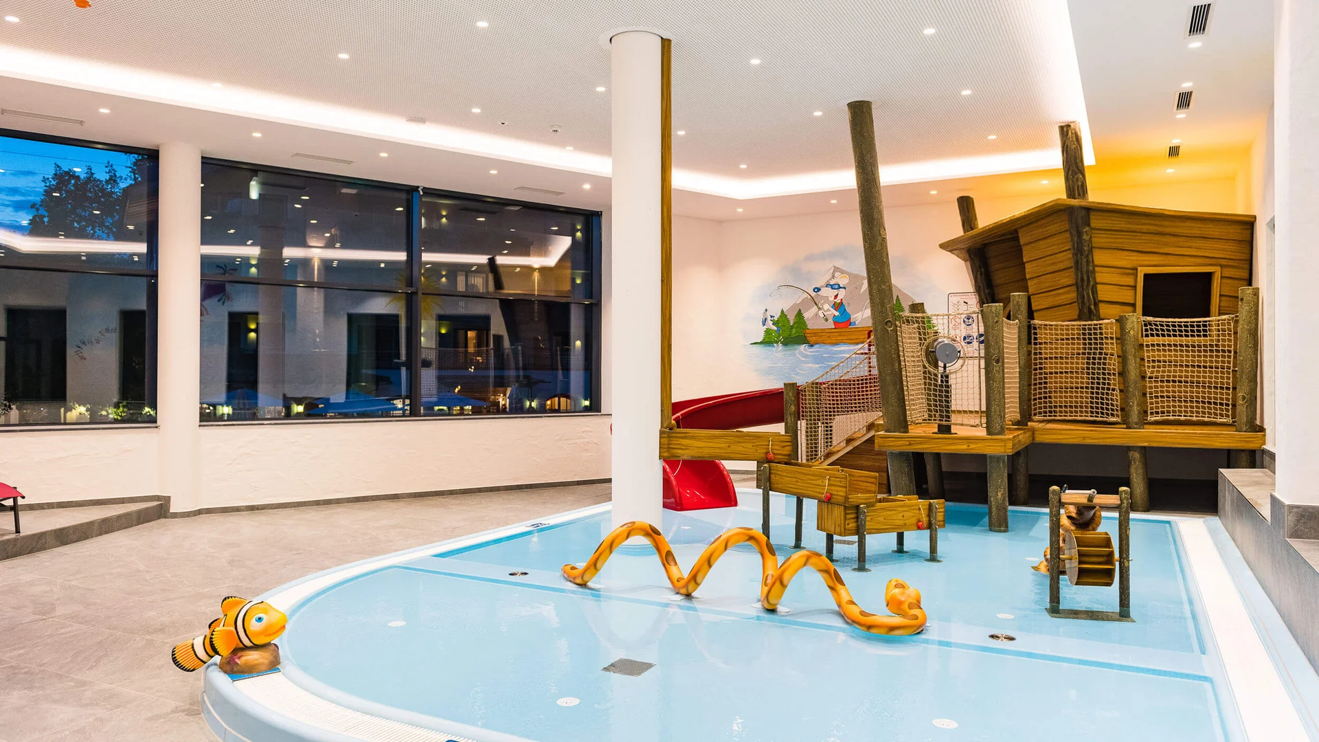 Area giochi per bambini con piscina bassa e struttura di scivolo in legno