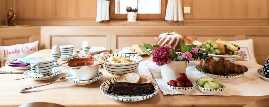 Bike & Kulinarik: Vom Gipfel in den Gourmethimmel © Raffael F. Lehner Gemütlicher Frühstückstisch mit Brot, Obst und Butter in traditioneller Holzstube