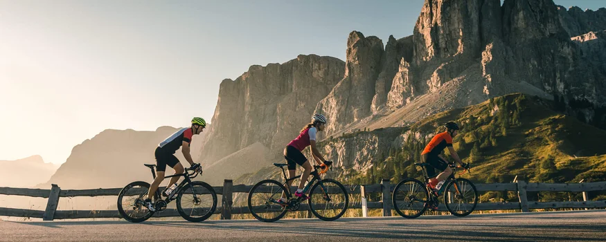 Hotel Gran Paradiso **** © Molography Drei Radfahrer fahren auf Bergstraße mit Felsen im Hintergrund bei Sonnenuntergang