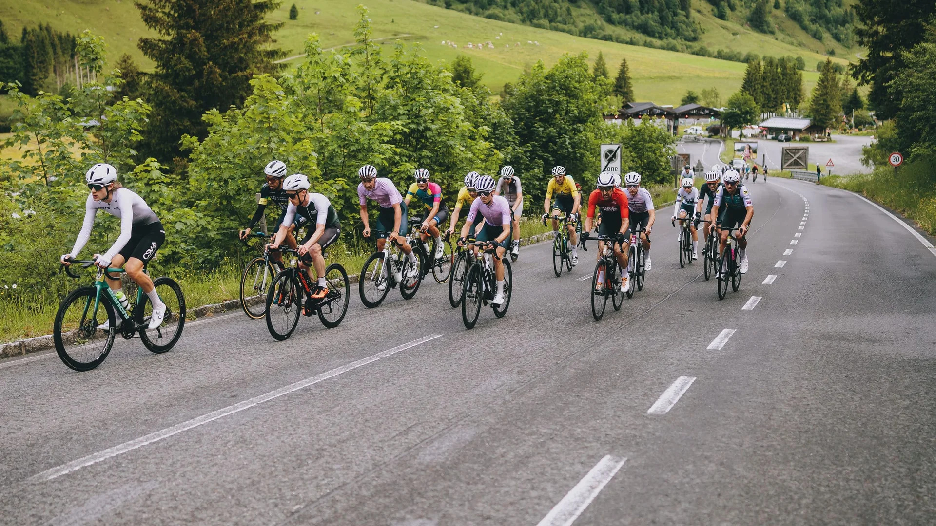 Glocknerkönig 2026 © BRUCK FUSCH GROSSGLOCKNER JFK Photography Gruppe von Radfahrern auf einer Straße in grüner Berglandschaft
