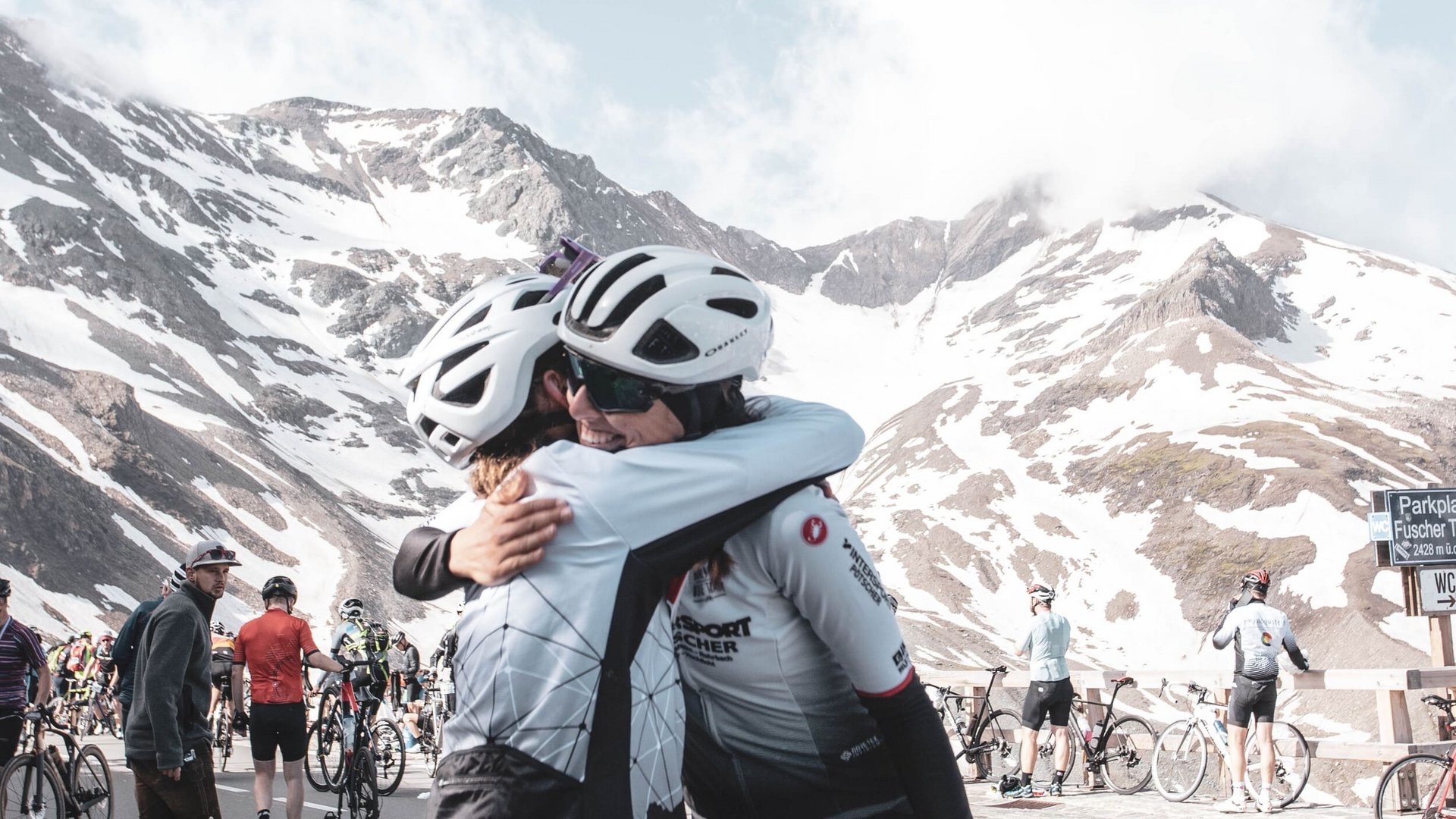 29. Glocknerkönig am 7. Juni 2026 © Kovac György Tourismusverband BRUCK FUSCH GROSSGLOCKNER Zwei Radfahrer umarmen sich vor schneebedeckten Bergen bei Radsportveranstaltung