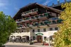 Collectief onderzoek © Zooom Christian Lorenz Traditioneel hotel met restaurant en bloemen op balkons