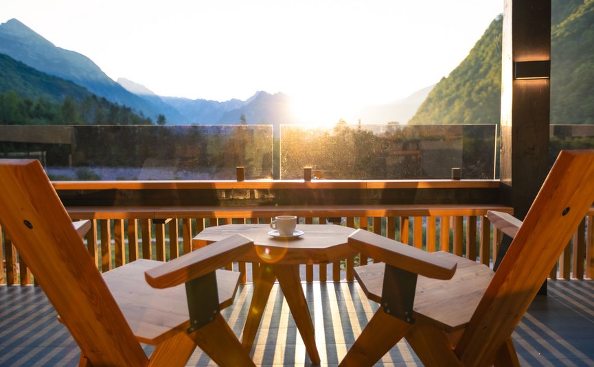 Hotel Boka *** © Hotel Boka Sonnenaufgang über Bergen mit Holzstuhl und Kaffeetasse auf Balkon