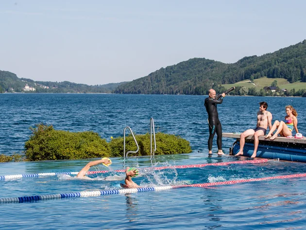 Ein Rennrad-Wochenende im SalzburgerLand – Salzkammergut © Erwin Haiden Schwimmer im Außenpool am See mit zwei Personen auf Steg und Trainer
