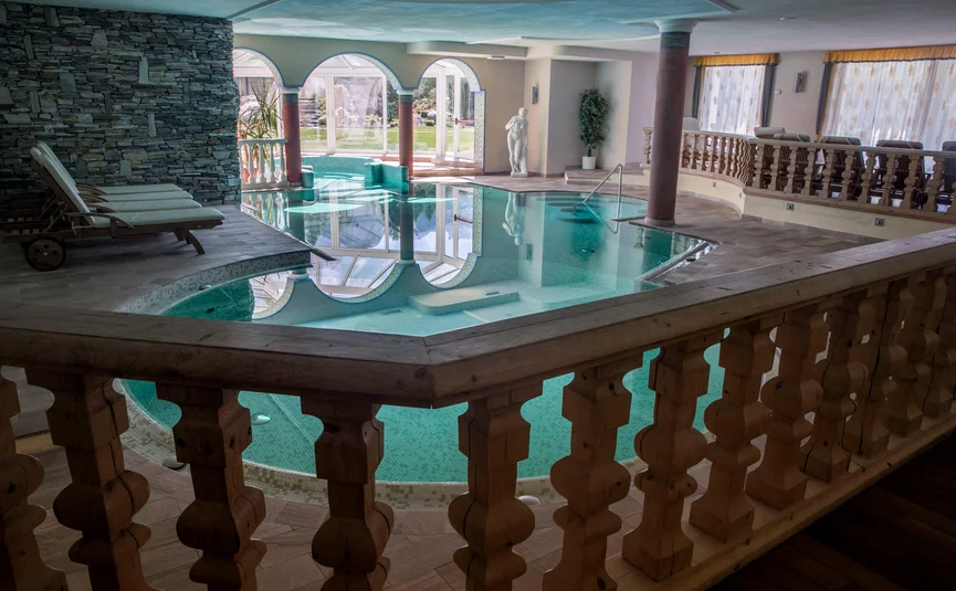 Hotel Gran Paradiso **** © Davide dal Mas Innenpool mit Liegestühlen, Säulen und Statue in luxuriösem Spa-Bereich