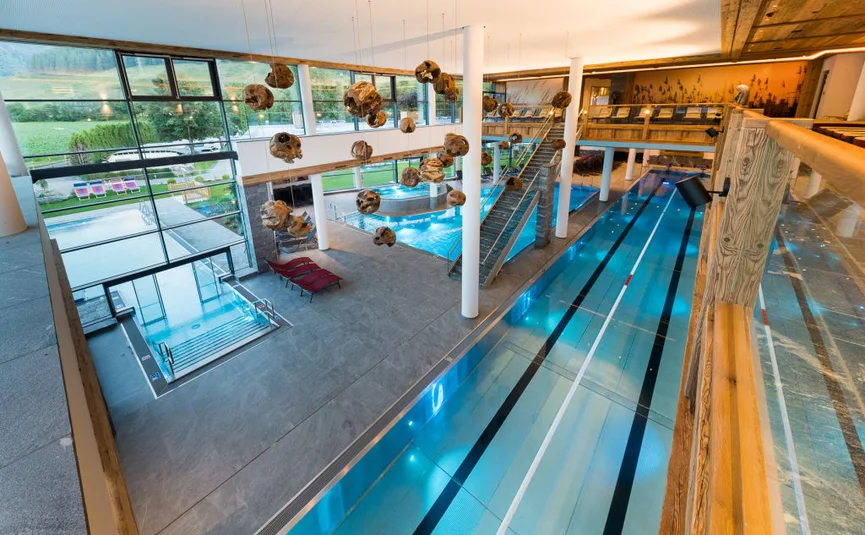 Piscina interna moderna con grandi finestre e decorazioni sospese