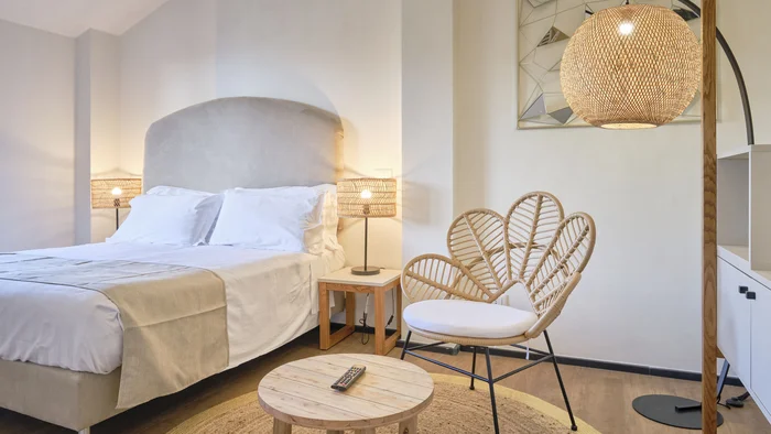 Villa Giada SpEace Resort: Mit deinem Rennrad aufs Zimmer © Villa Giada spEace & Bike Resort Helles Schlafzimmer mit gemütlichem Bett, Rattanstuhl und warmem Licht