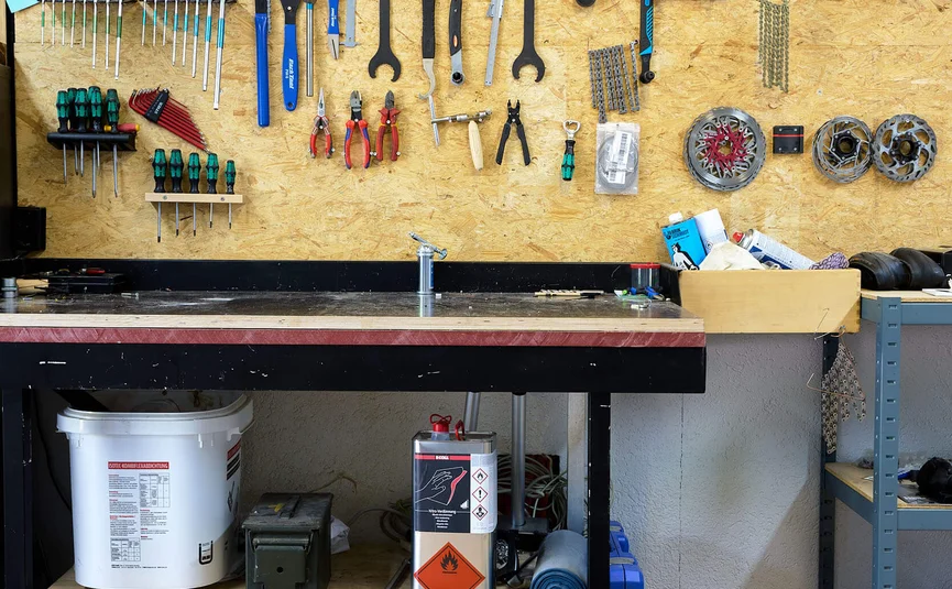 Fietsgereedschap en onderdelen aan de wand van een werkbank