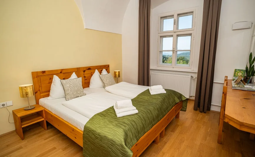 Gemütliches Doppelzimmer mit Holzbetten und Blick aus dem Fenster