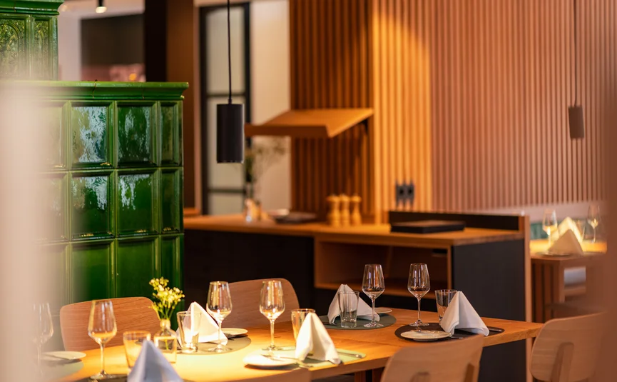 Posthorn Hotel-Ristorante Ristorante dall’atmosfera calda, con tavoli apparecchiati, calici e rivestimenti verdi