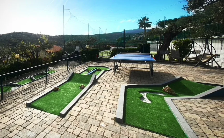 Outdoor miniature golf course with two holes and a ping pong table