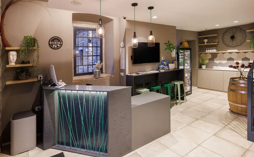 Hotel Vila Robida *** © Jaka Ivancic Reception area with desk, bar stools, and modern lighting