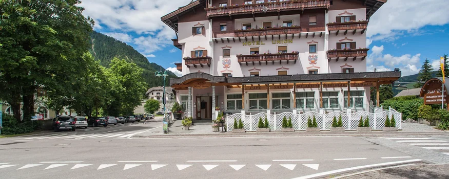 Großes Hotel Union mit Balkonen vor Berglandschaft und blauem Himmel