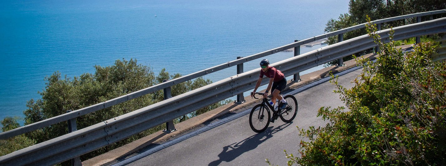 Radfahrer fährt eine Küstenstraße mit Blick auf das Meer entlang