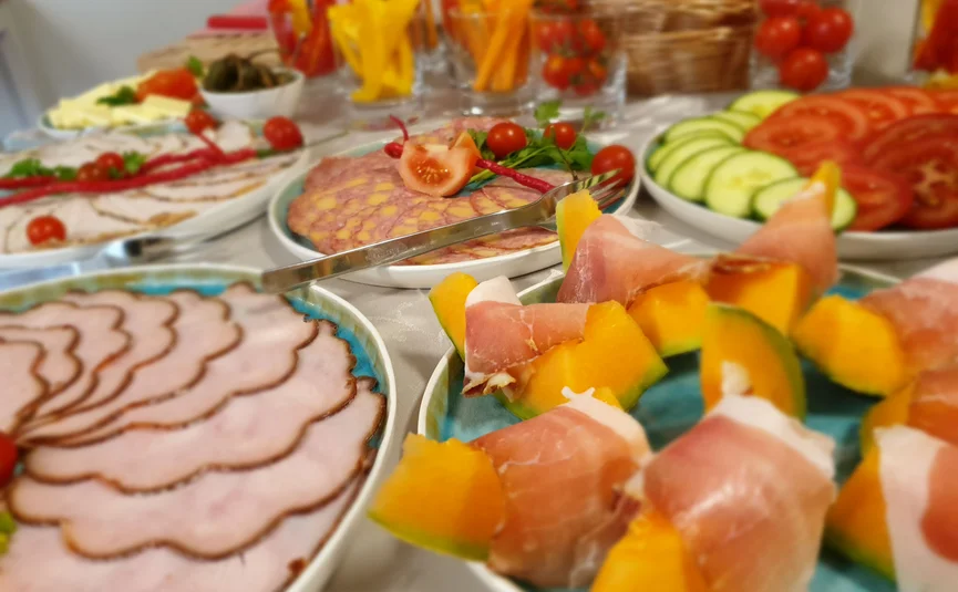 Appetizer plate with ham, melon, cold cuts and vegetable sticks