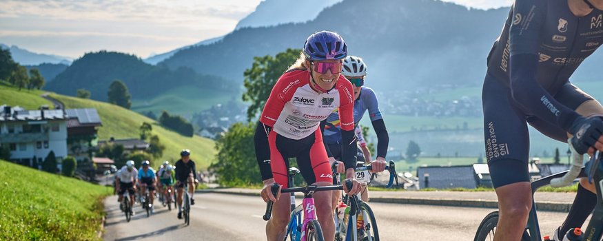 Der Kufsteinerland Radmarathon Radsportler fahren bergauf auf einer Straße mit Bergen im Hintergrund